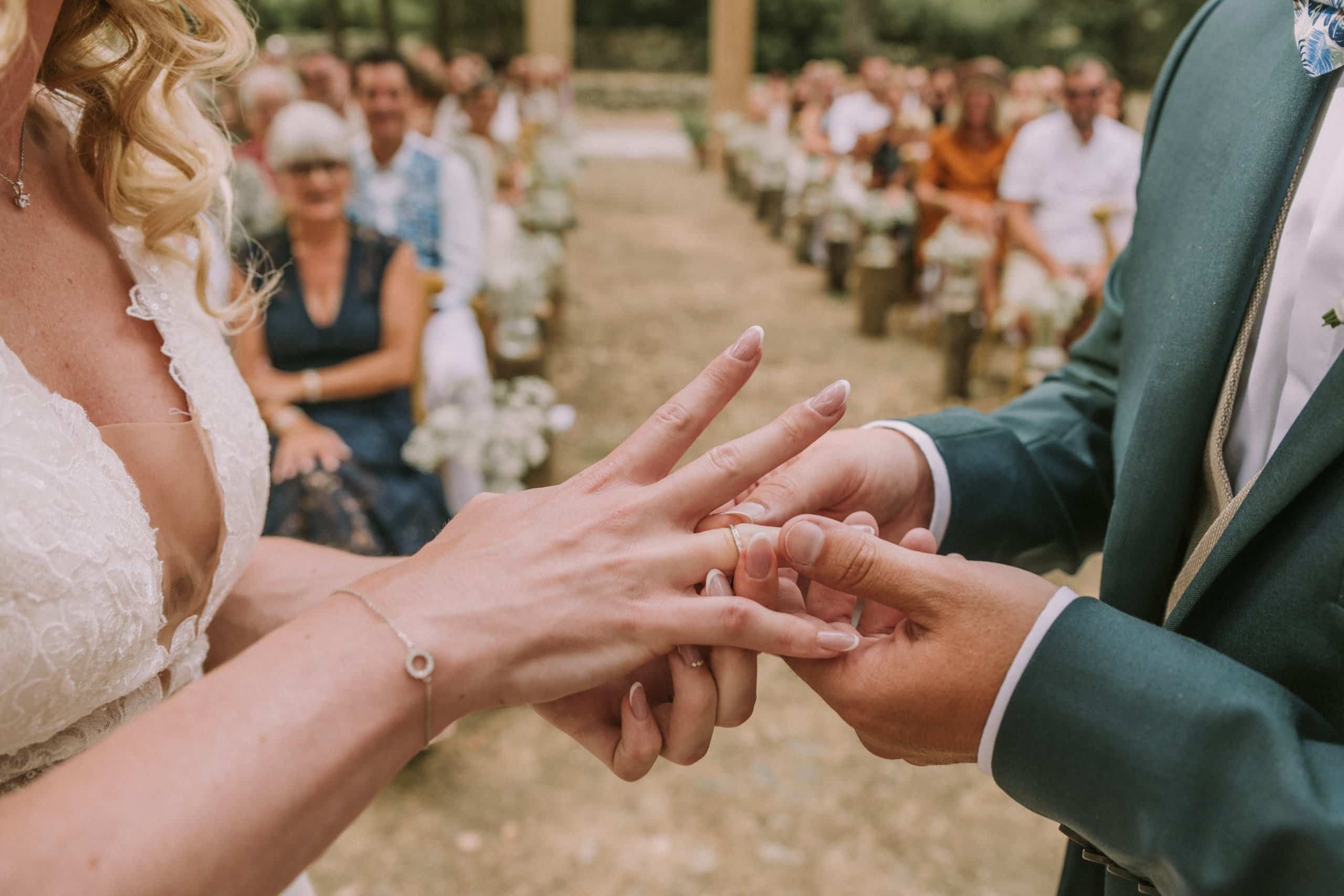 Échange des alliances pendant la cérémonie Échange des alliances entre les mariés pendant une cérémonie de mariage en extérieur