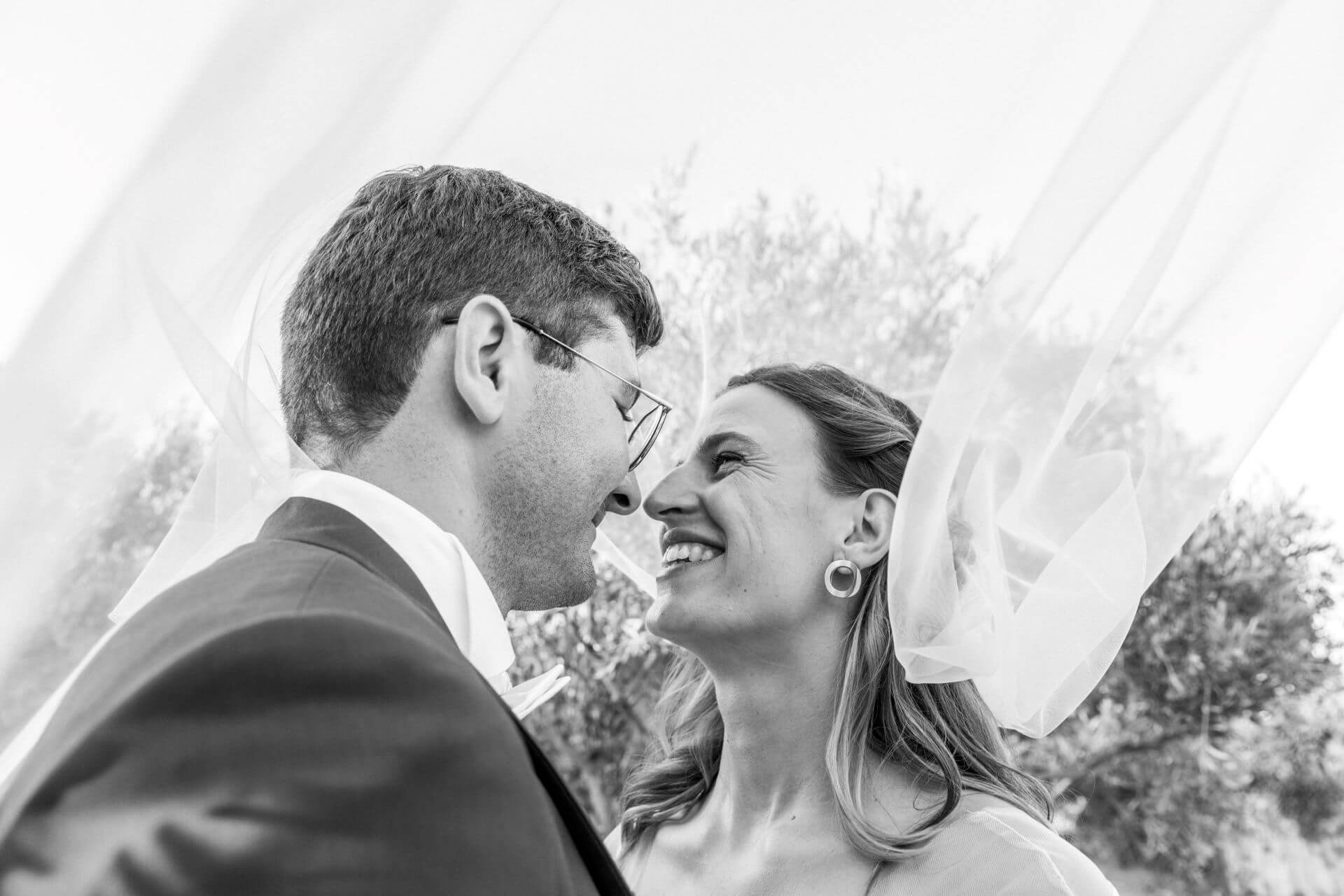Séance couple au Domaine Le Mas Neuf : la mariée ajuste son voile avec élégance