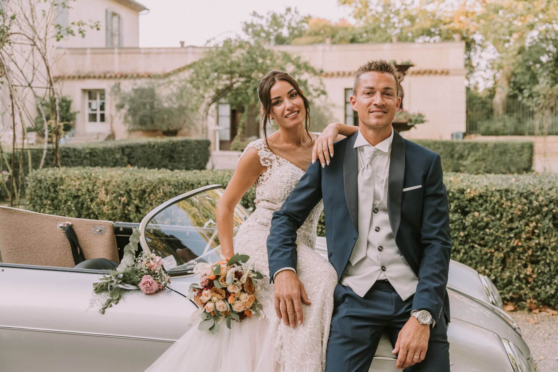 Mariés photographiés comme dans un magazine avec une voiture de collection